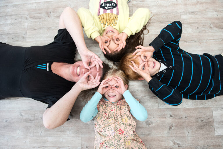 Claudia Böschel liegt im Kreis mit Kindern und macht Sehtraining